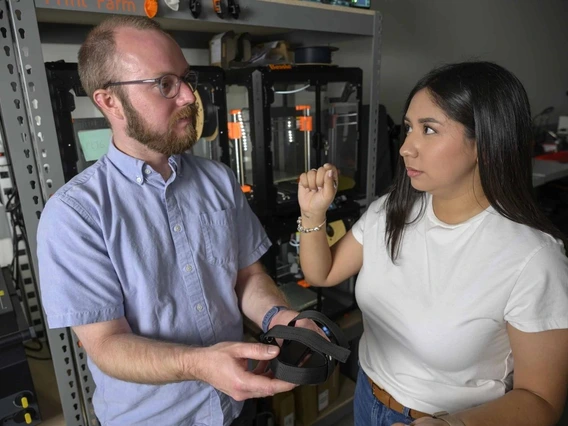 A man and a young woman hold a bike pedal.