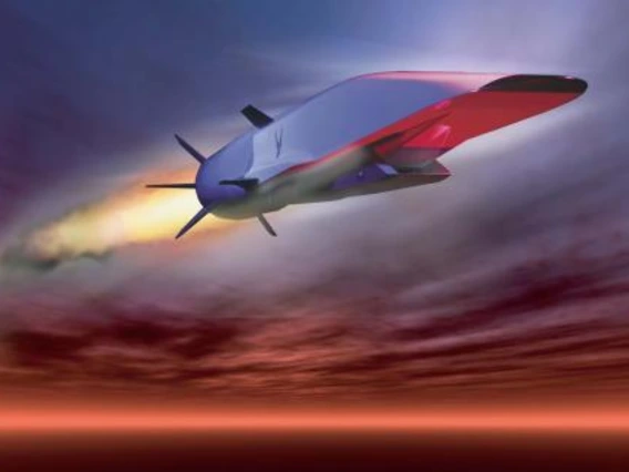 A hypersonic vehicle flys across a sunset sky.