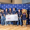 Students pose with a big check